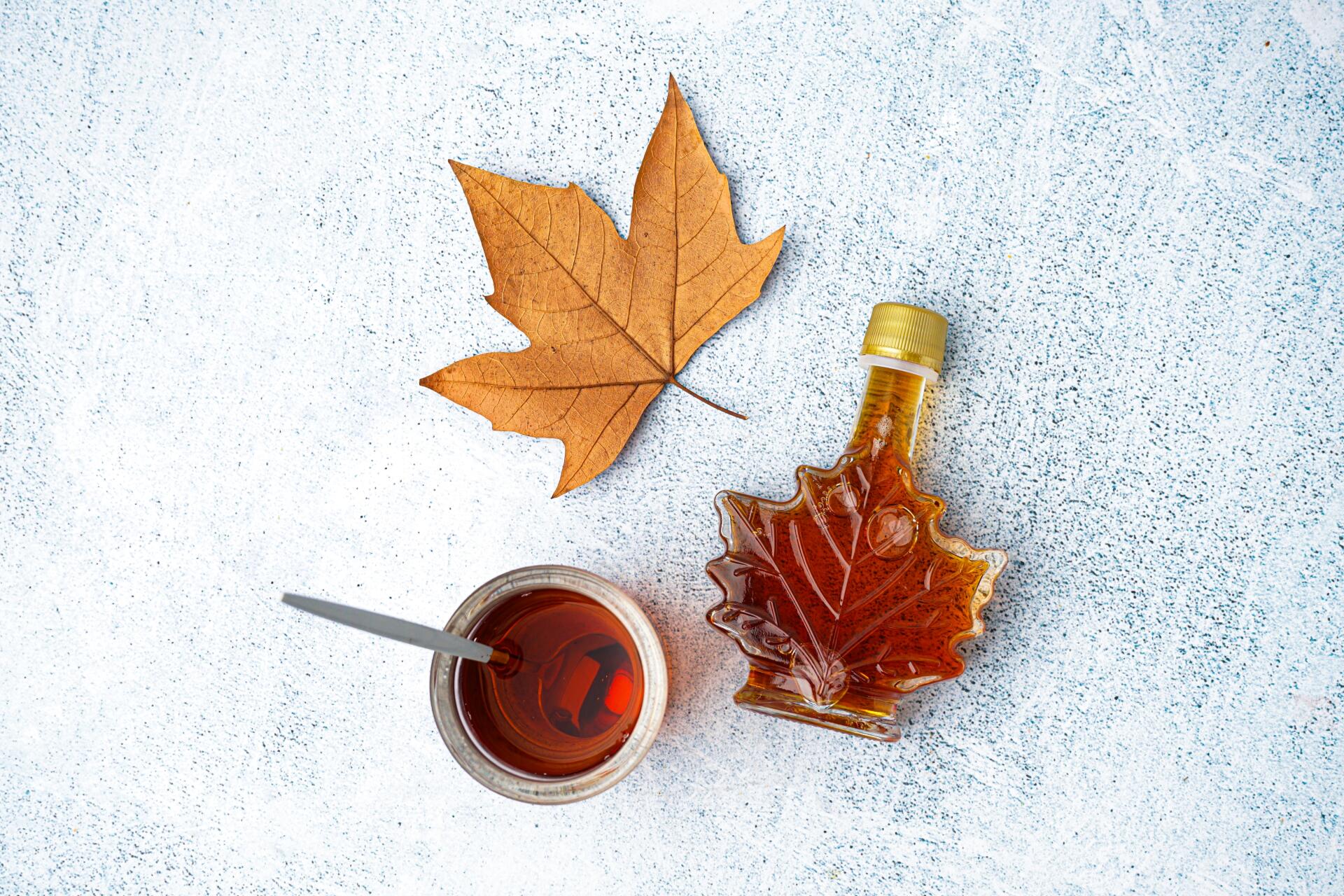 Maple syrup & maple leaf on textured background